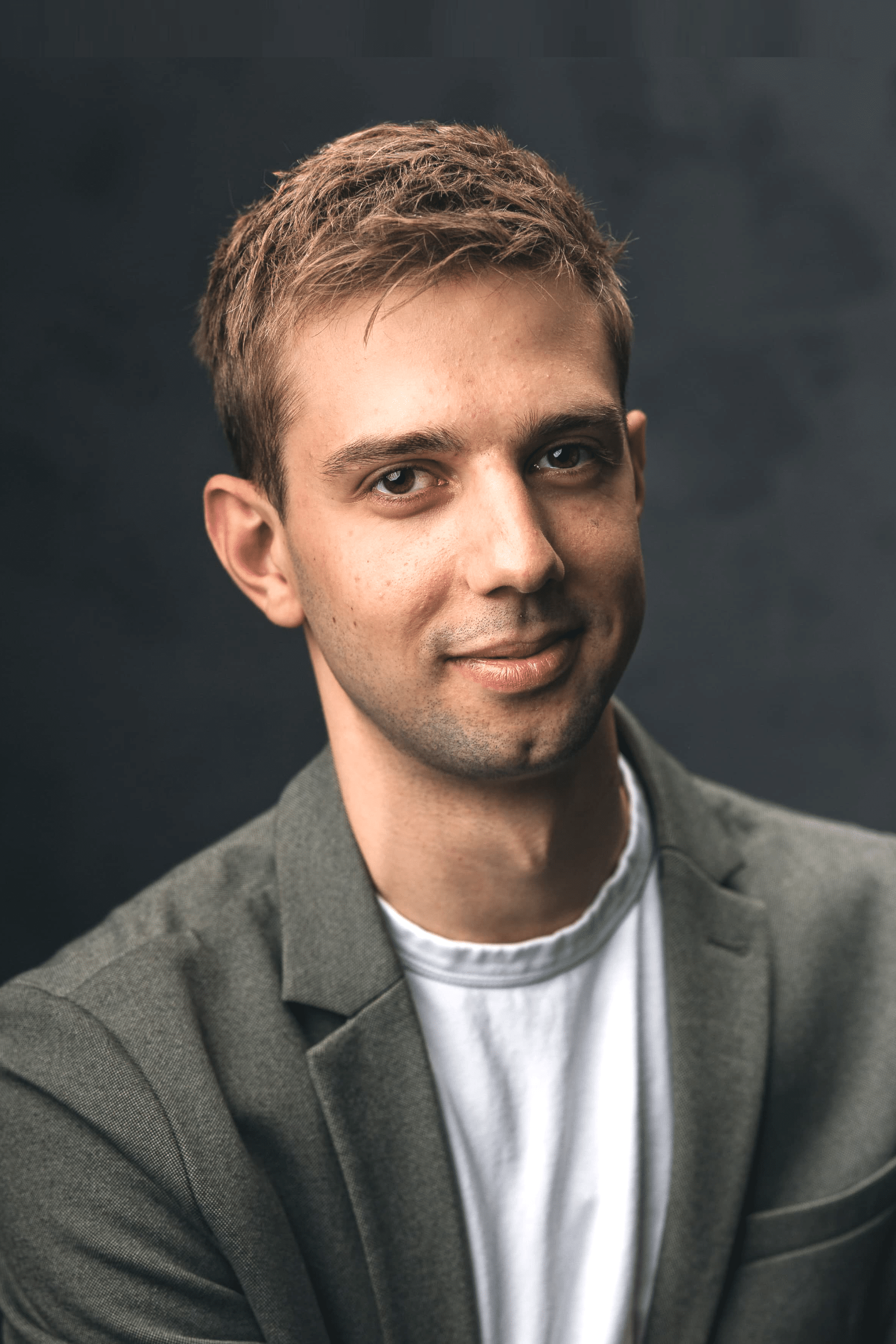 Mann in grauem Sakko lächelt leicht